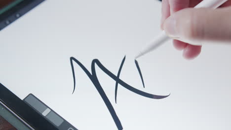 close up of a man digitally drawing the word art on a touchpad screen