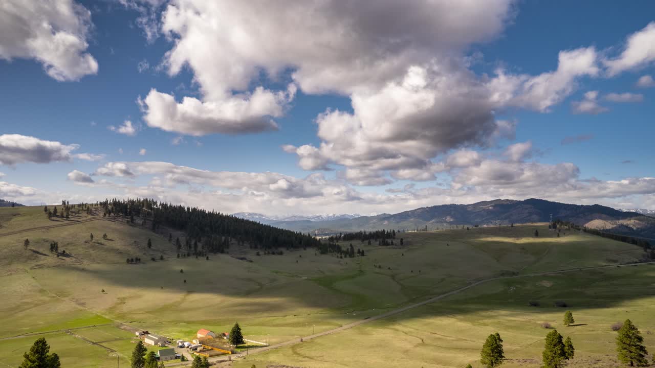 Nuvole in movimento proiettano ombre scure su un paesaggio collinare verde e fertile, Washington orientale.