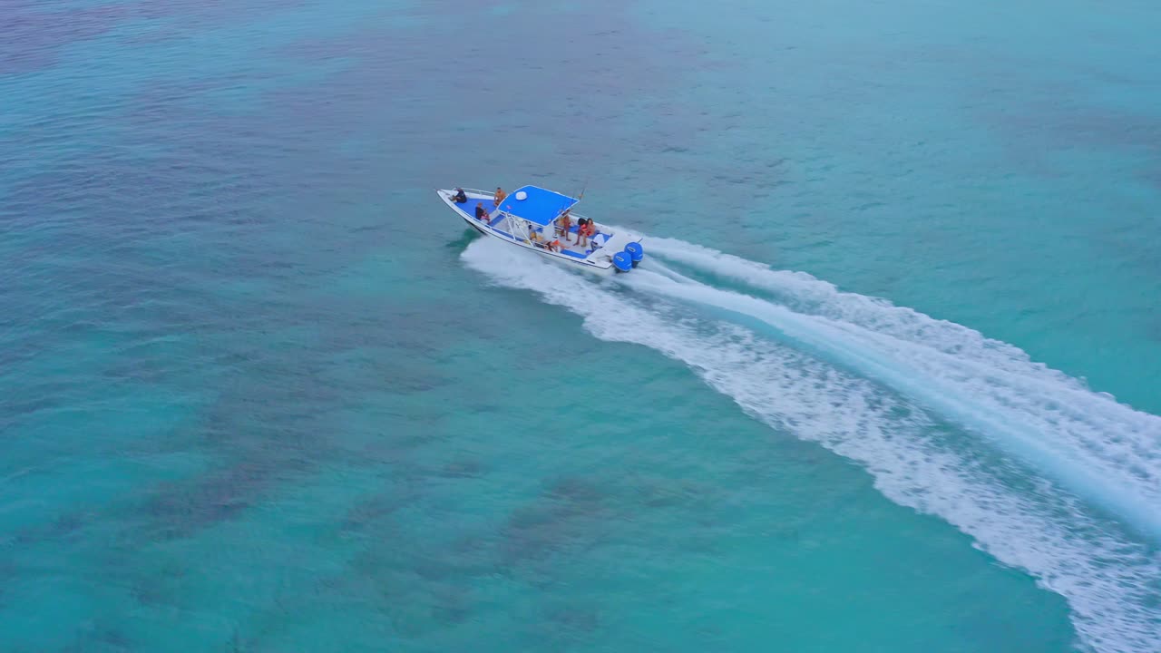 turistas en lancha navegando en bahia de las aguilas dejando estela blanca