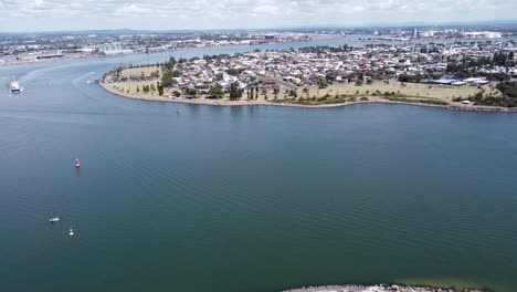 Aerial-view-of-a-river-bend-with-boats-and-a-large-town-in-Australia