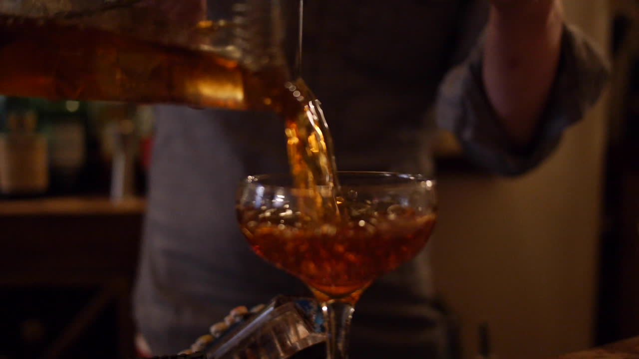 Bartender Pours Manhattan Cocktail to Serve at Bar, Mixology Dive Bar