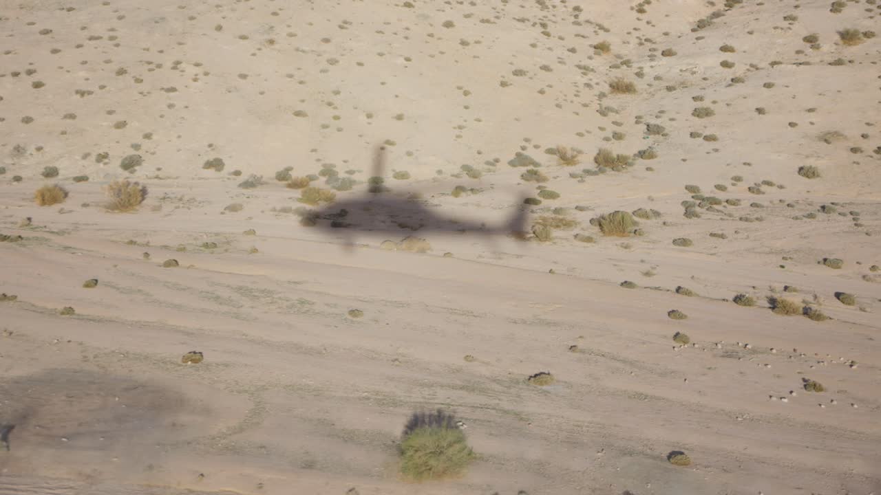 Shadow of black hawk helicopter on the ground