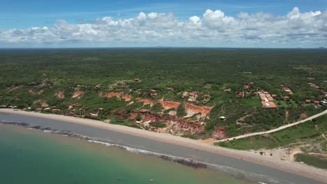 movimiento panorámico con dron en una pequeña playa paradisíaca con mar verde y aguas tranquilas en el noreste de brasil
