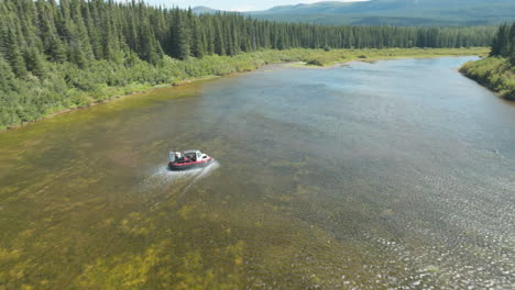 Gorgeous-drone-shot-following-a-speedy-air-boat-travelling-up-a-river-in-Newfoundland-and-Labrador,-Canada