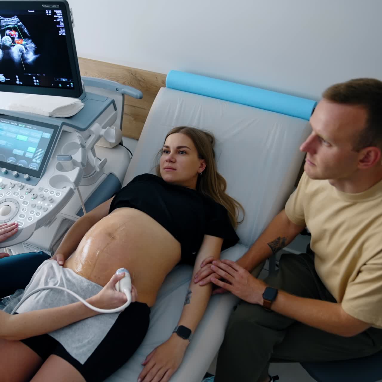 Expecting couple is at the cabinet of ultrasound examination. Check up before labor. Top view