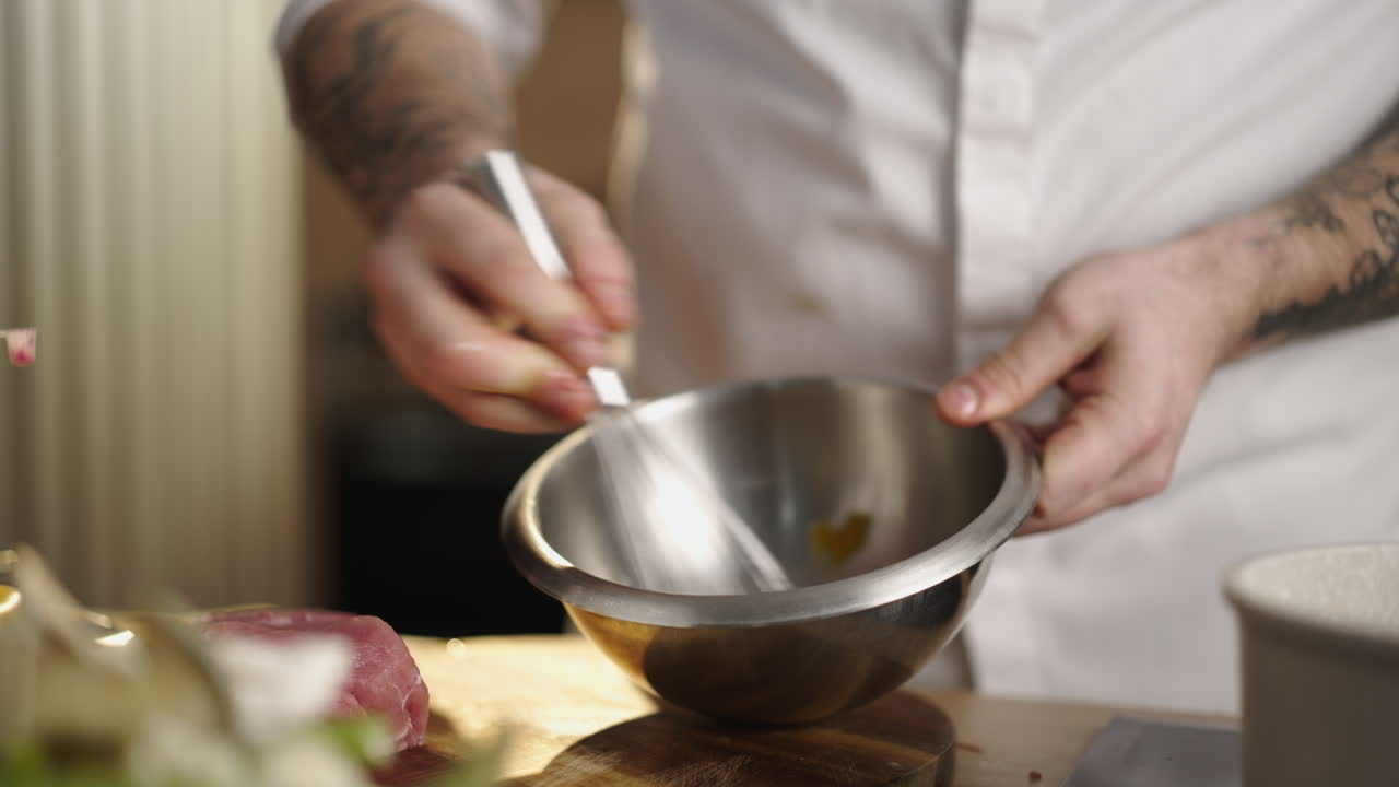 Chef preparing food with whisk and bowl