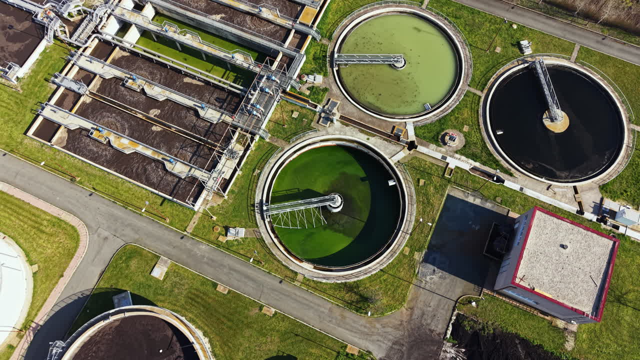 Water treatment facility operates during daytime at urban location with multiple tanks and processing equipment present