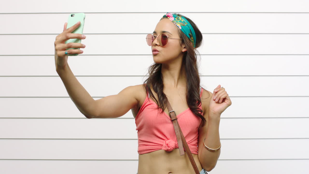 Trendy young girl taking selfies isolated against