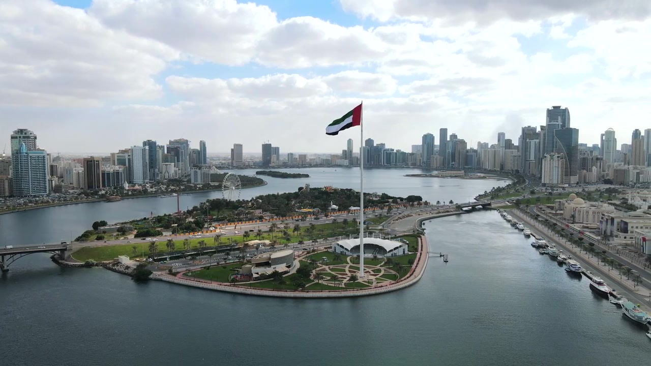 Una gigantesca bandiera degli Emirati Arabi Uniti sventola sulla città di Sharjah, Emirati Arabi Uniti.