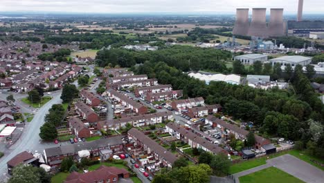 vista aérea del barrio residencial industrial británico a través de la estación de energía, casas y calles suburbanas, amplia órbita izquierda