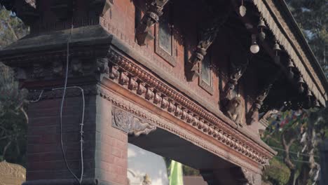 monkey climbing on the brick arch decorated in bells at the entrance of swayambhunath stupa in kathmandu, nepal. - close up shot