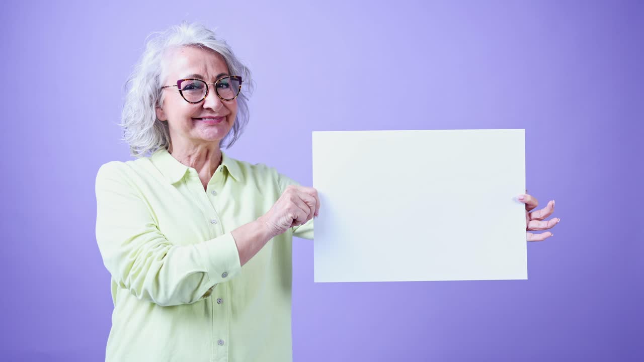 Expressive Senior Woman Holding Blank Sign on Purple Background