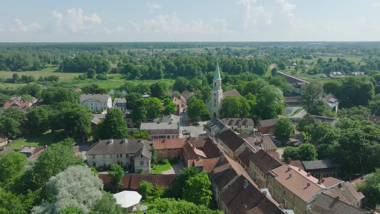 vista aérea del casco antiguo de kuldiga, casas con tejas rojas, iglesia evangélica luterana de santa catalina, día soleado, destino de viaje, disparo de avión no tripulado avanzando