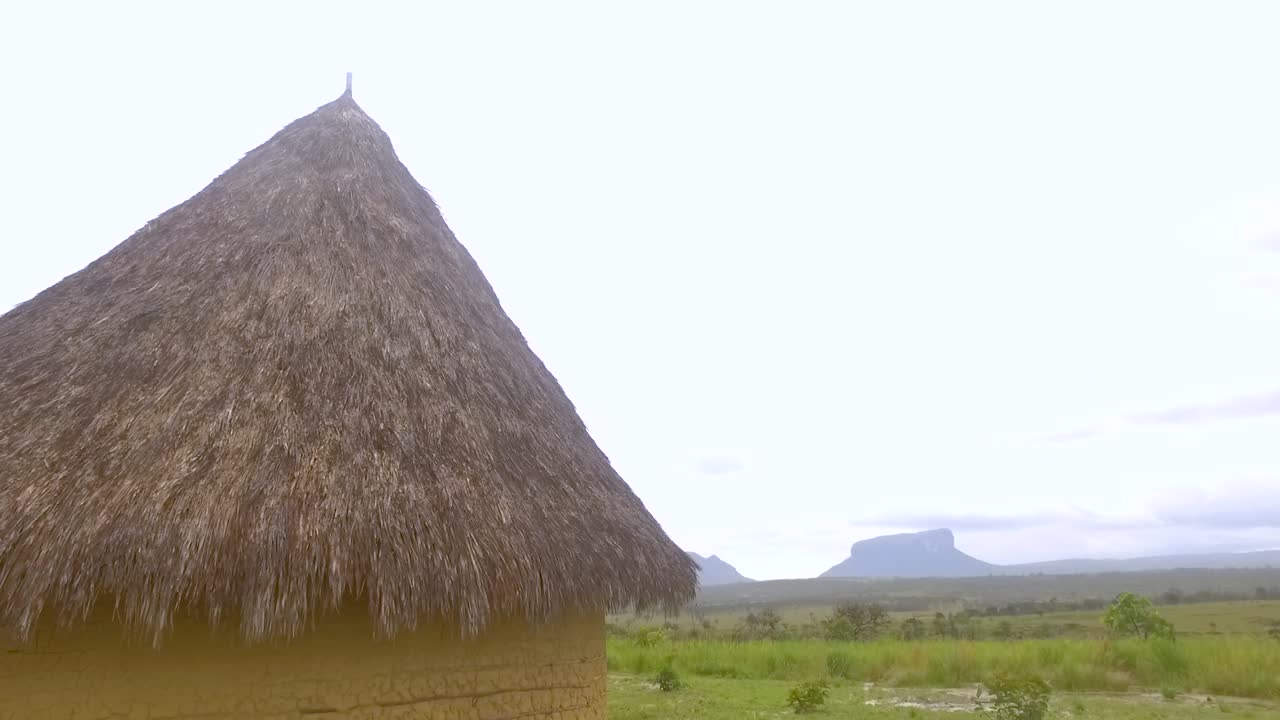 cabaña indígena en mayupa, canaima, venezuela, con increíbles tepuyes en la parte trasera durante un día lluvioso