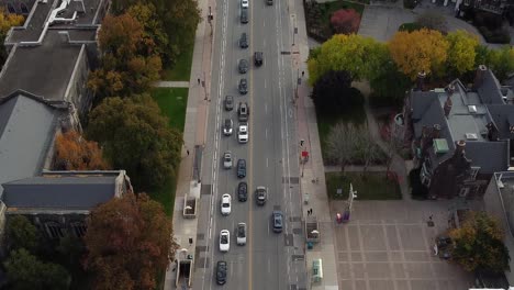 Cropped-Aerial-of-city-street-traffic-surrounded-by-buildings-and-large-colorful-urban-park