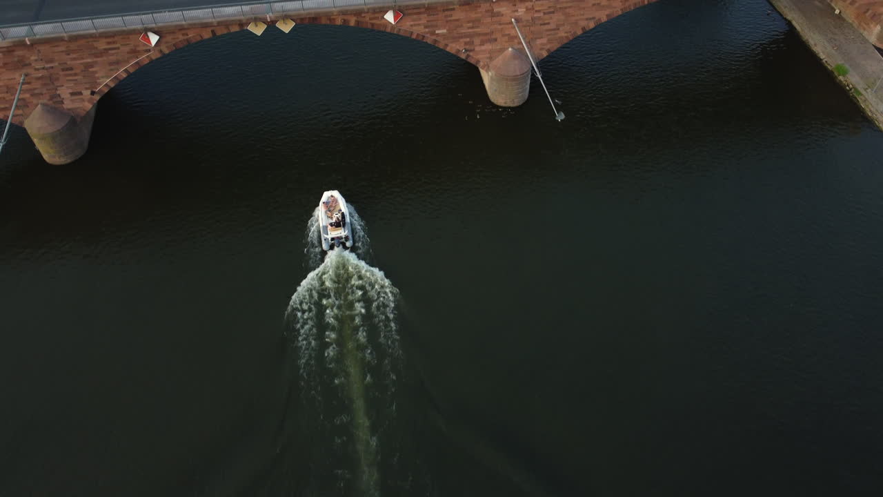 Aerial View of a Speedboat on a River Under a Bridge