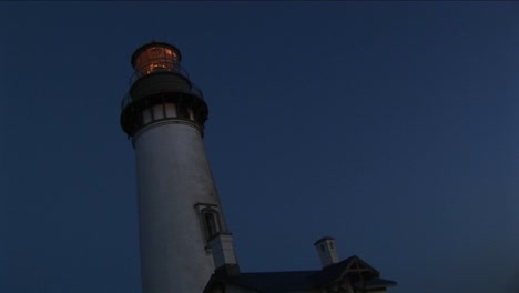 uma visão wormseye de uma torre de farol e farol à noite