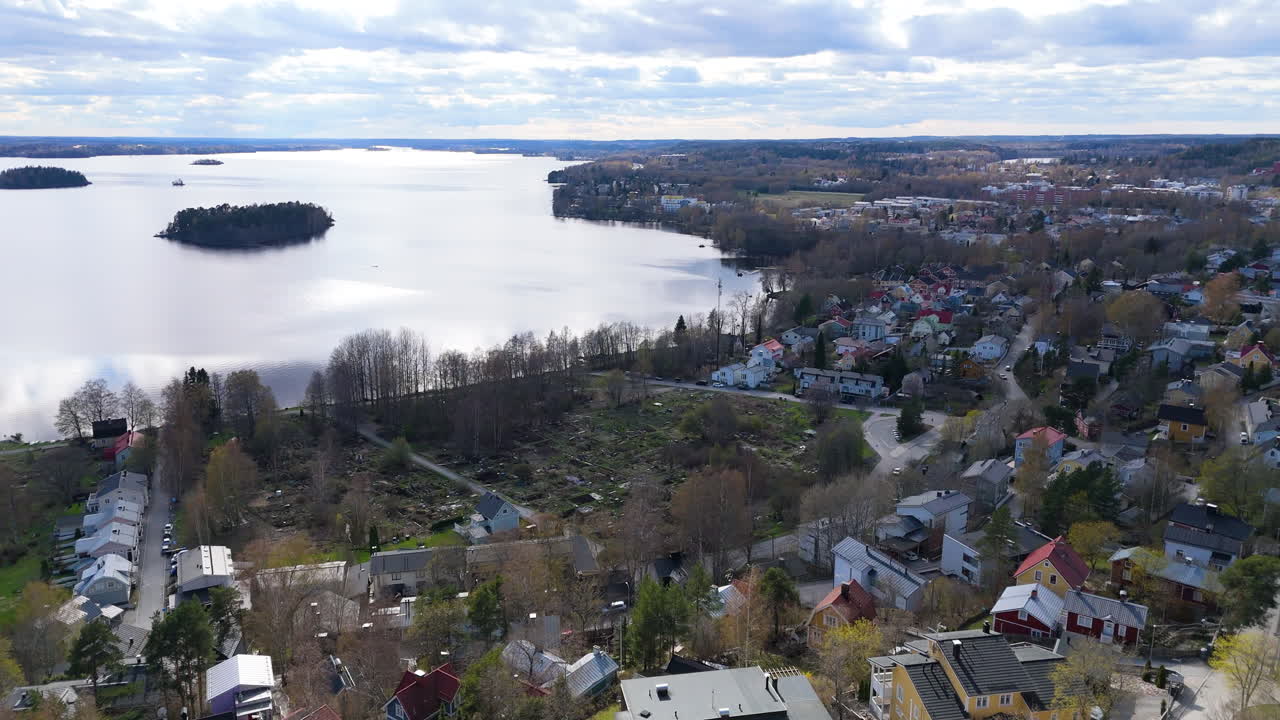 Beautiful nordic wooden houses on a hill, old school building and a lake. Tampere Finland. Drone flying over the hill in 4k prores. View over Pispala and Tahmela regions and Saunasaari island.