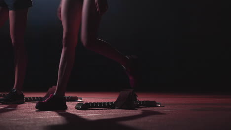 Tres-Chicas-Vestidas-De-Negro-Están-En-Las-Plataformas-De-Salida-Para-Comenzar-La-Carrera-En-La-Competencia.