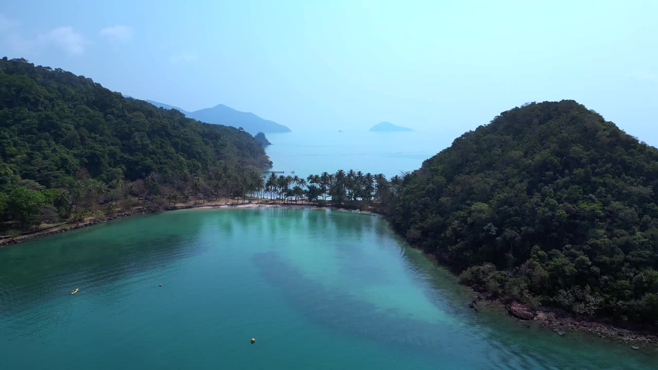 Scenic aerial view of lush green hills and turquoise waters on Koh Chang Ngam Island. Tremendous aerial view flight ascending drone
