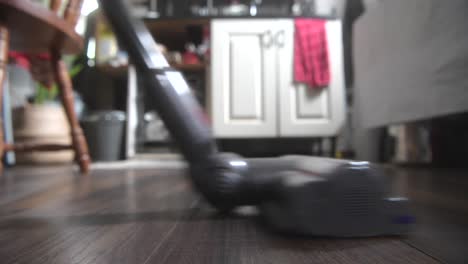 Vacuuming-a-walnut-kitchen-floor-macro-close-up-shot