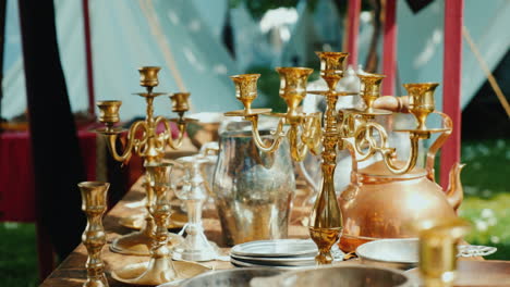 antique dishes candlesticks and other items in an antique outdoor tent