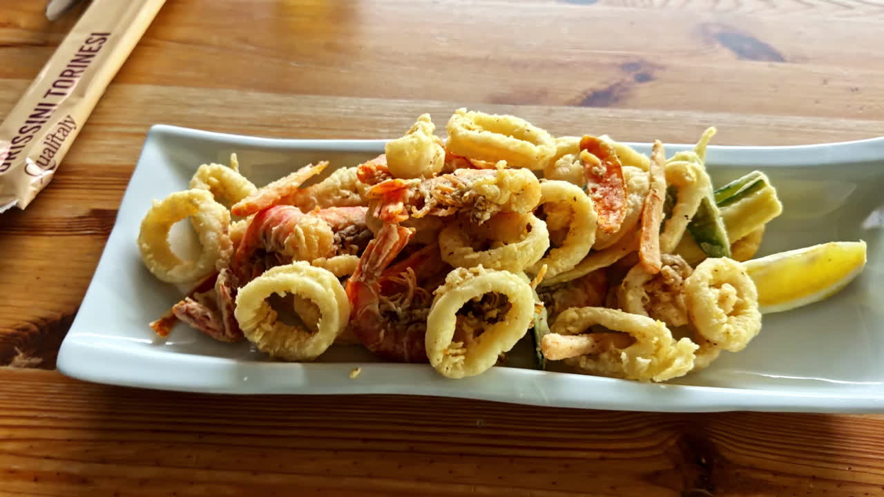 Plate of mixed seafood on a wooden table at Lago d'Iseo in Italy