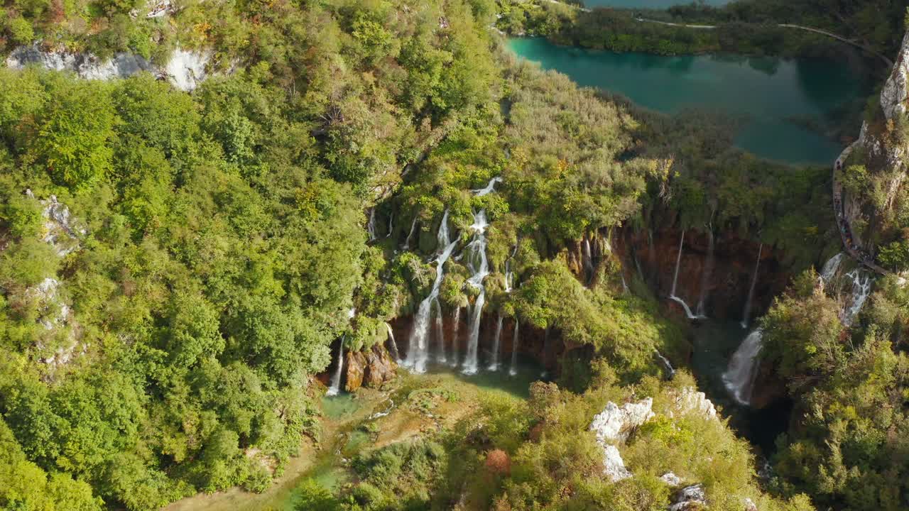 increíble vista aérea de drones de lagos turquesas brillantes conectados con cascadas entre acantilados rocosos y bosques densos