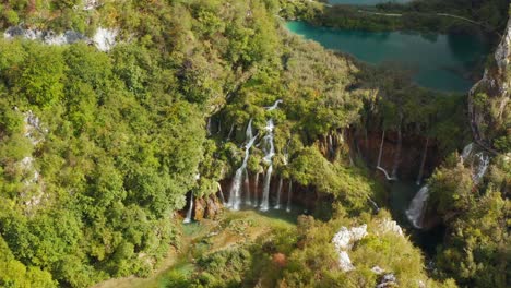 incroyable vue aérienne par drone de lacs turquoise brillants reliés à des cascades entre des falaises rocheuses et une forêt dense