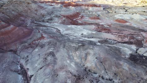 Aerial-4k-drone-flyover-view-of-Bentonite-Hills,-Utah,-at-golden-hour-with-colorful-mars-like-landscape-appear-as-softly-contoured,-banded-hills-in-varying-hues-of-brown,-red,-purple,-blue,-and-green