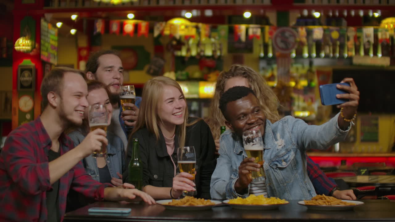 gelukkige mannelijke vrienden die selfie maken en bier drinken in een bar of pub. mensen vrijetijdsvriendschap technologie en feestconcept - gelukkige mannenvrienden die selfie nemen