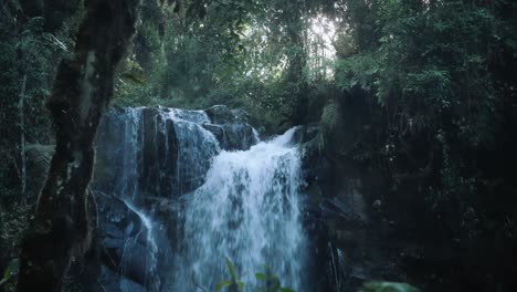majestic waterfall with rays of sun shining through the rainforest