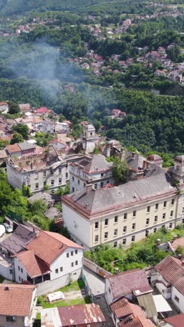abandoned military barracks surrounded by forest and rooftops near sarajevo, vertical