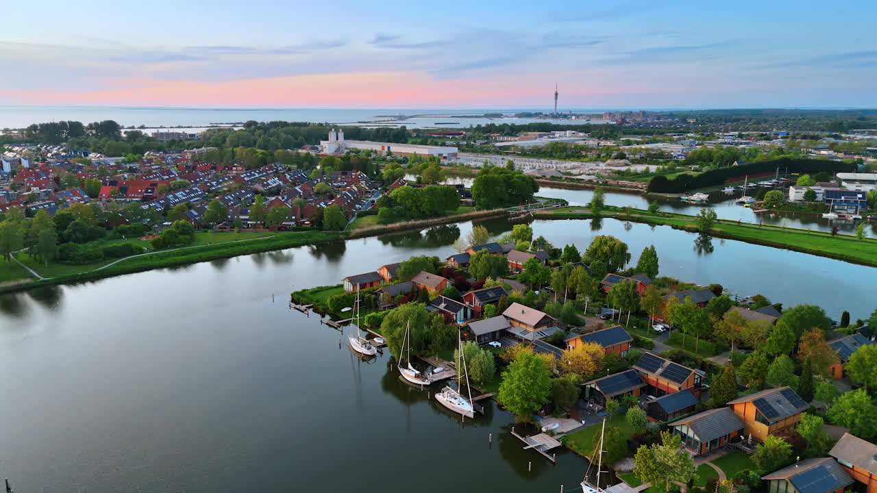 Beautiful village among the multiple canals. Lovely houses in the lush greenery. The Netherlands. Aerial view.