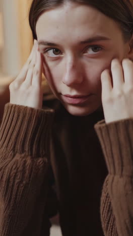 young woman hiding her face and looking at camera