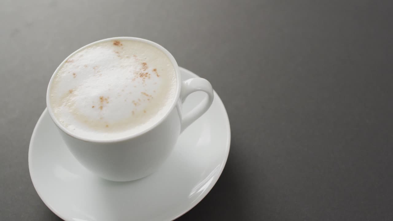 video de una taza blanca de café con leche sobre fondo negro