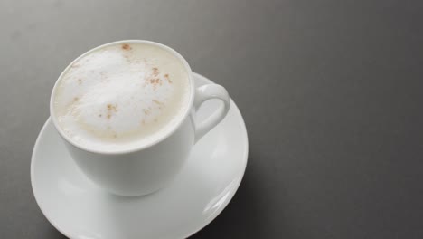 video of white cup of coffee with milk over black background