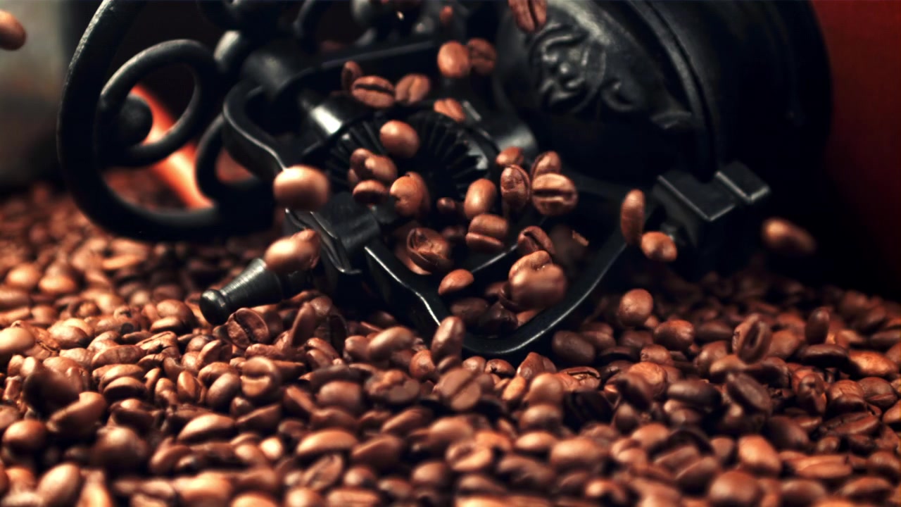 Chicchi di caffè tostati che cadono al rallentatore su un mucchio