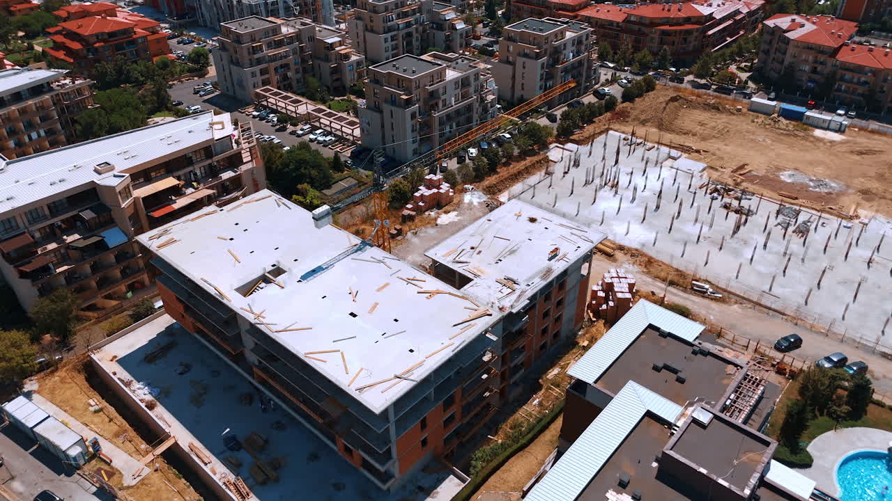 Urban residential construction site. Construction workers are busy at the site of a new residential building in a developing urban neighborhood