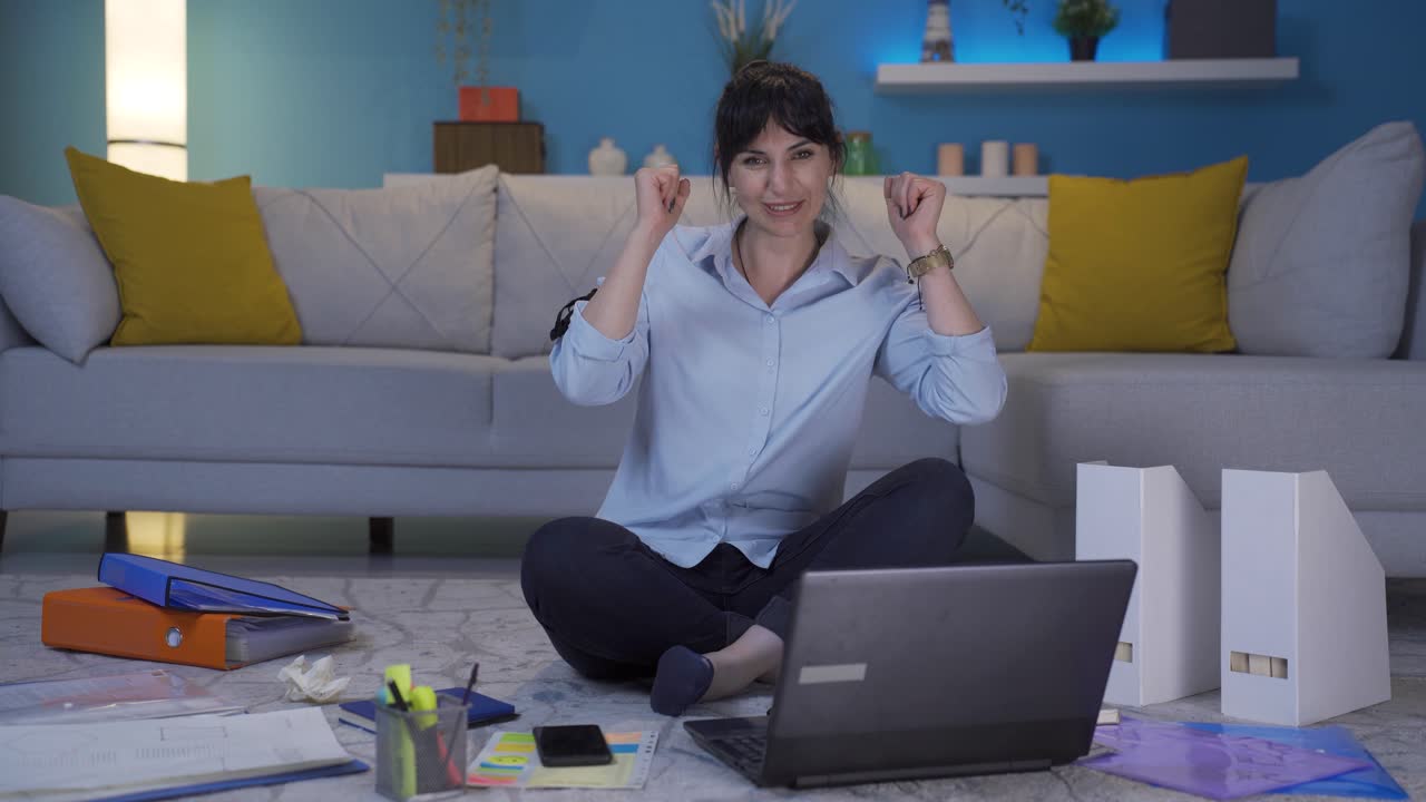 mujer trabajadora de oficina en casa experimentando alegría mirando a la cámara.