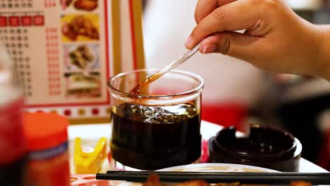 hand stirring chili sauce at street food stall