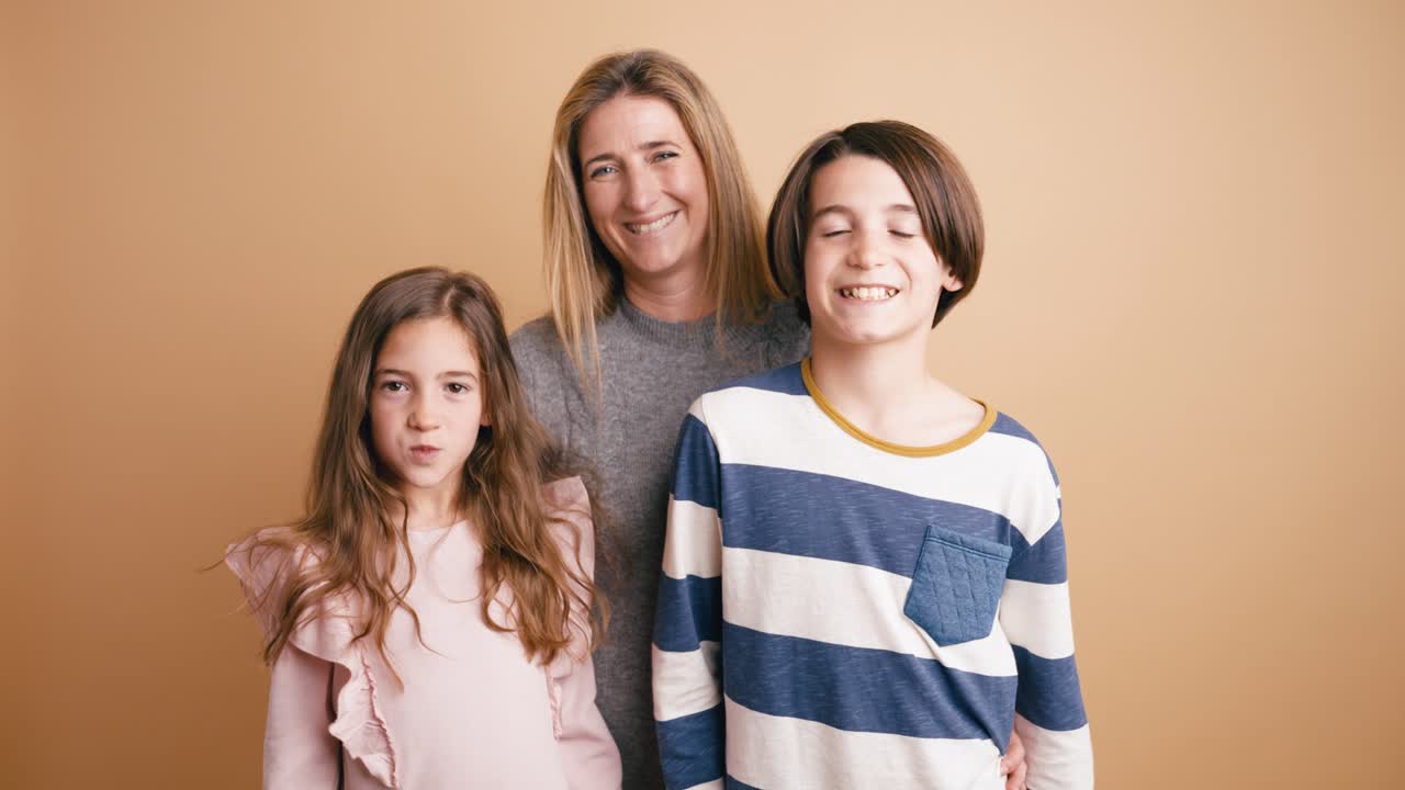 Madre felice e i suoi due figli che posano in uno studio