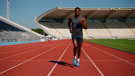 male athlete running on a stadium track