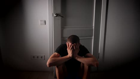 man hiding from hands reaching through a door, symbolizing fear and mental struggle