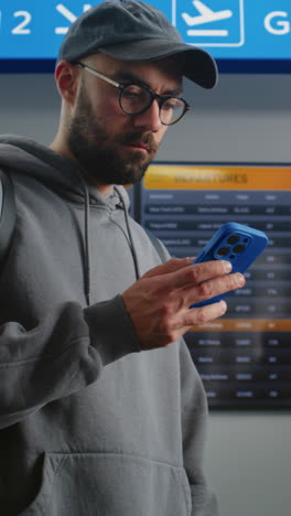 man checking flight schedule at airport