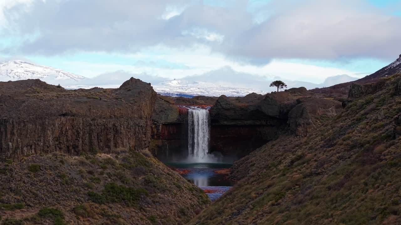 Aerial footage showcasing Salto del Agrio, a breathtaking waterfall in Neuquén, Argentina, surrounded by rugged volcanic cliffs