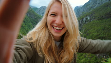 happy woman taking selfie in norwegian fjord