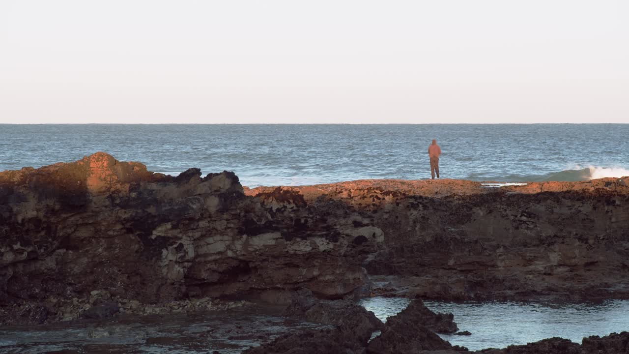 Persona in piedi su una scogliera, che osserva l'oceano o il mare, vista calma e stabile, spazio per il testo, Cascais in Portogallo.