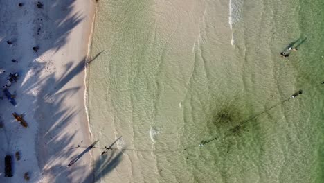 vista aérea de arriba hacia abajo de la translúcida orilla de la playa esmeralda con turistas, vietnam