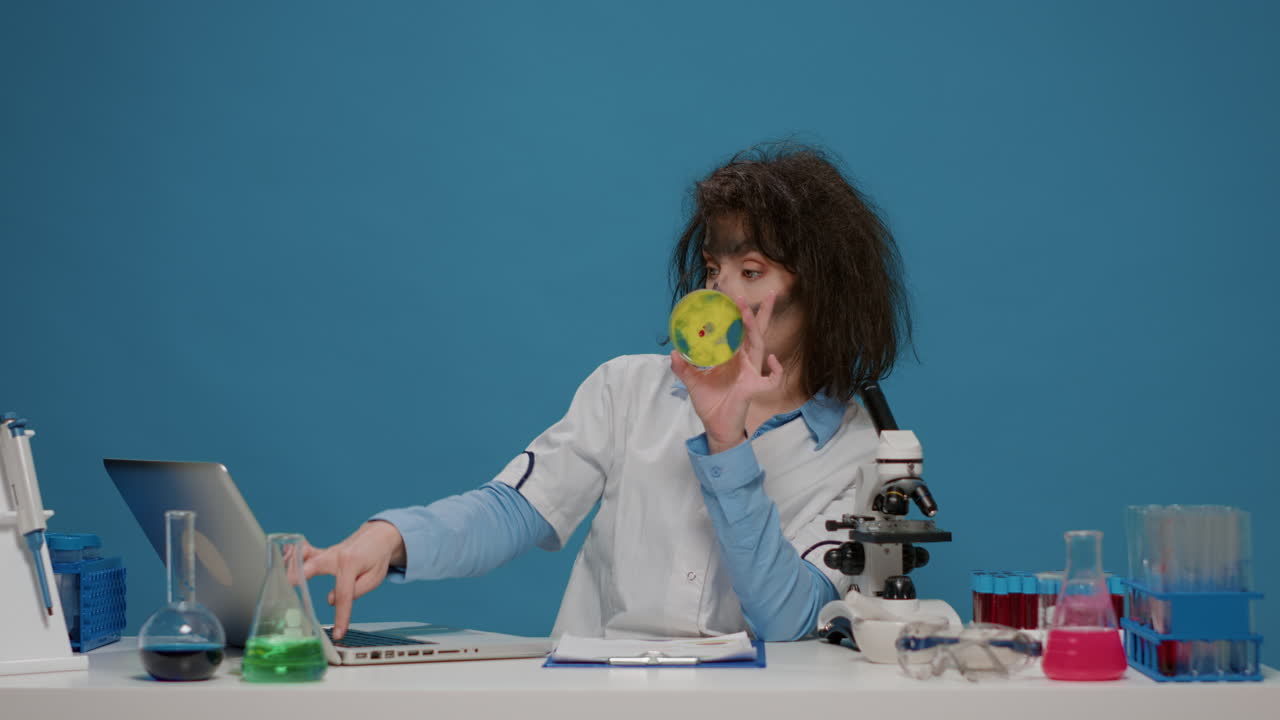 Funny insane scientist looking at substance in petri dish